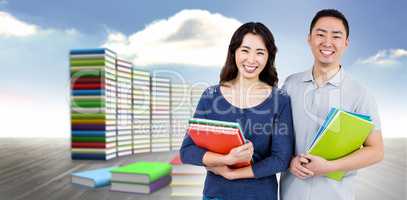 Composite image of happy couple holding books