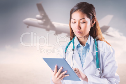 Composite image of asian doctor using tablet