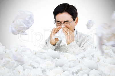 Composite image of smiling man using a tissue