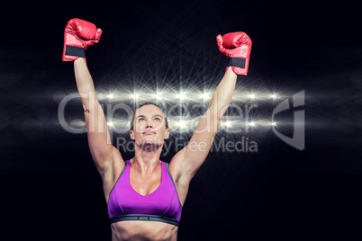 Composite image of winner female boxer with arms raised