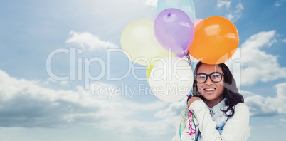 Composite image of asian woman holding colorful balloons