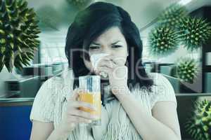 Composite image of woman holding a glass of orange juice while s