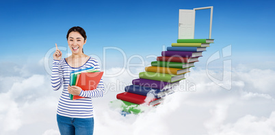 Composite image of cheerful woman pointing up while holding file