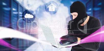 Composite image of focused burglar standing holding laptop