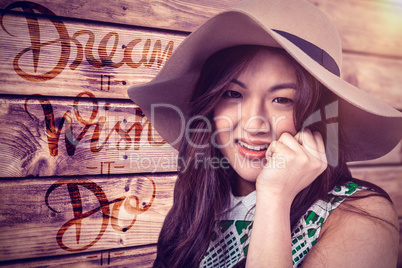 Composite image of asian woman with hat posing for camera