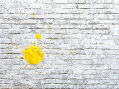 White brick wall stained spots of paint of yellow  colors