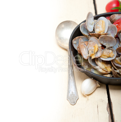 fresh clams on an iron skillet