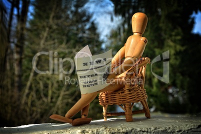 Holzfigur liest Zeitung
