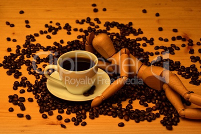 Kaffee Tasse und Kaffeebohnen mit Holzfigur auf Holztisch