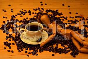 Kaffee Tasse und Kaffeebohnen mit Holzfigur auf Holztisch