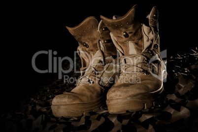 military boots on camouflage net and black backround