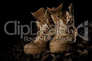 military boots on camouflage net and black backround
