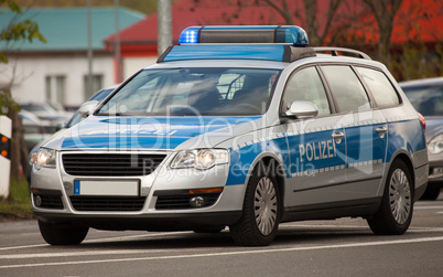 german police patrol car with flashing blue lights on the street