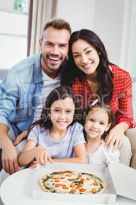 Family of four enjoying pizza at home