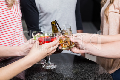 Group of friends toasting with beer and cocktails