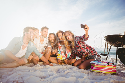 Happy friends taking selfie with smartphone