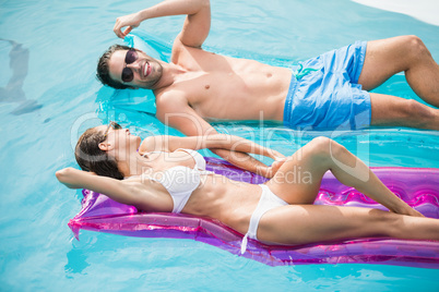 Couple smiling while relaxing on inflatable raft