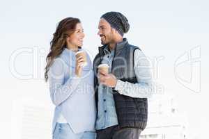 Happy young couple holding disposable coffee cup