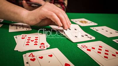 Close up of female hands holding cards and playing solitaire