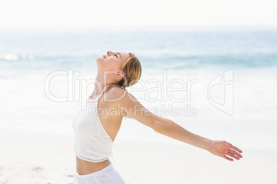 Beautiful woman stretching her arms on the beach