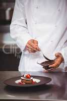 Chef putting chocolate sauce on a dessert