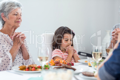 Family praying together before meal