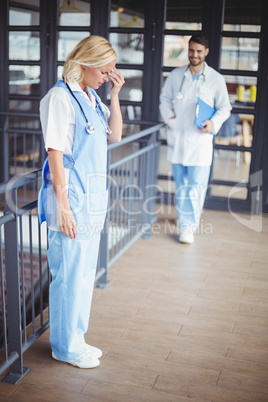 Full length of female doctor suffering from headache