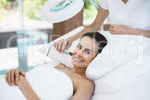 Portrait of smiling young woman receiving facial massage