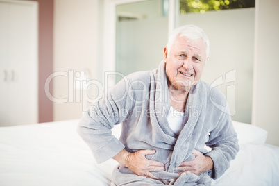 Portrait of senior man frowning with stomach ache