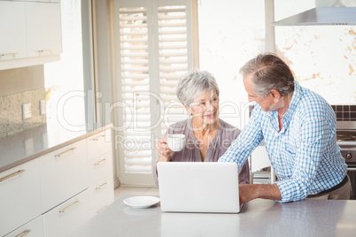 Senior couple interacting in kitchen