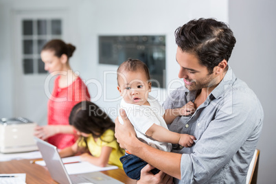 Father carrying baby at home