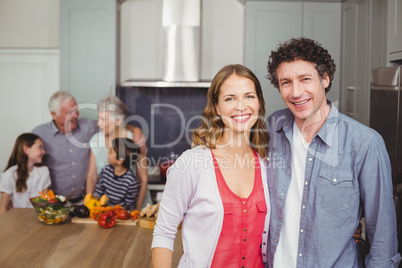 Portrait of smiling couple with family in kitchen