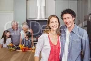 Portrait of smiling couple with family in kitchen