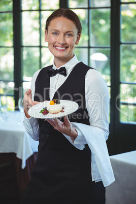Smiling waitress holding a plate