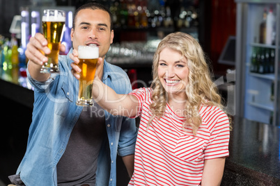 Smilinh couple holding beer