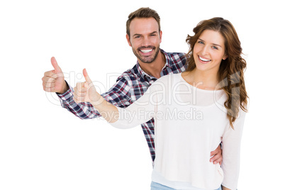 Happy young couple putting thumbs up