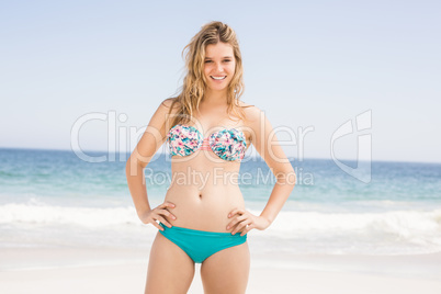 Happy woman in bikini standing on the beach