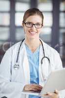 Portrait of smiling female doctor working on laptop