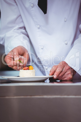 Chef putting finishing touch on dessert