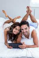 Portrait of smiling couple using digital tablet