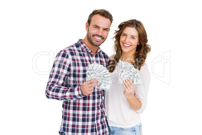 Happy young couple holding fanned out currency notes