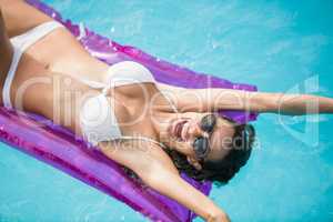 Cheerful young woman swimming with inflatable raft