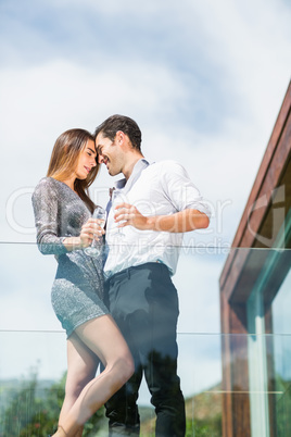 Romantic couple with champagne at balcony in resort