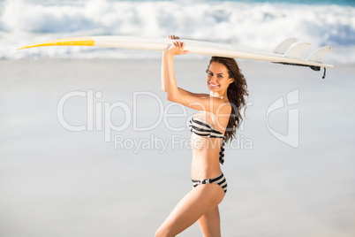 Woman holding surfboard at the beach