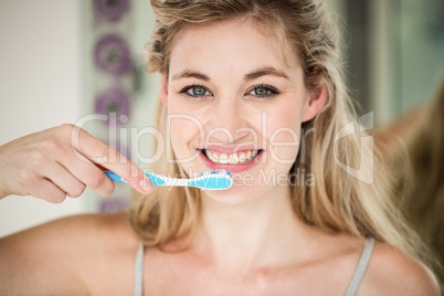 Portrait of smiling woman brushing teeth