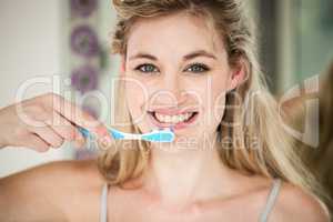 Portrait of smiling woman brushing teeth