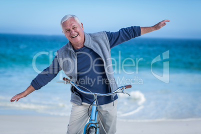 Senior man with a bike outstretching arms