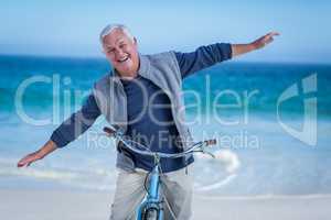Senior man with a bike outstretching arms