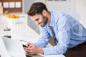 Happy man using laptop and phone