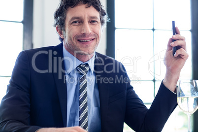 Happy businessman holding a mobile phone